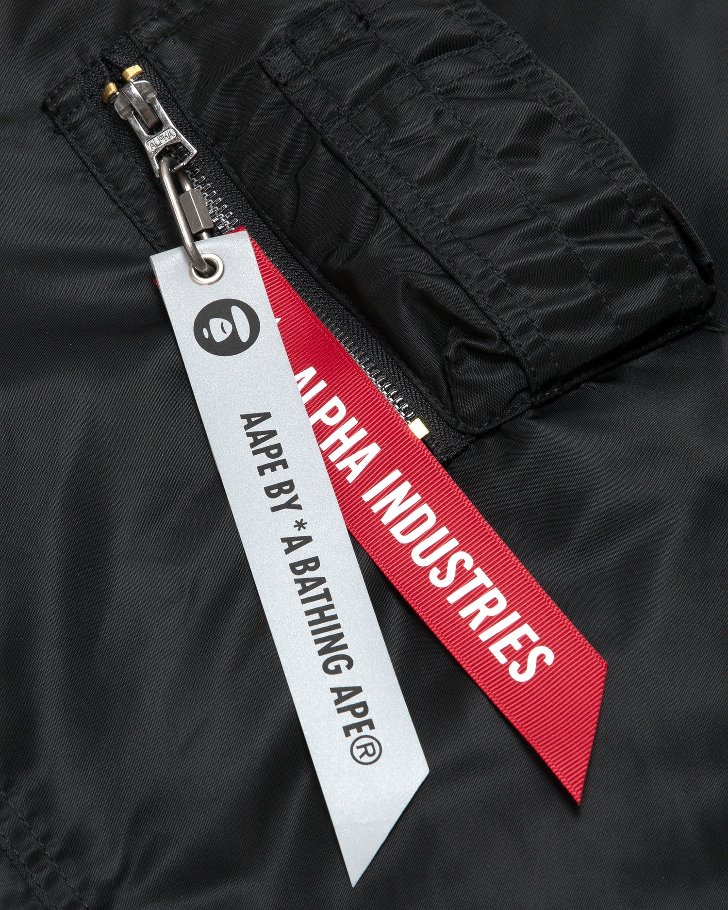 AAPE X Alpha Industries Moonface embossed bomber jacket | Aape